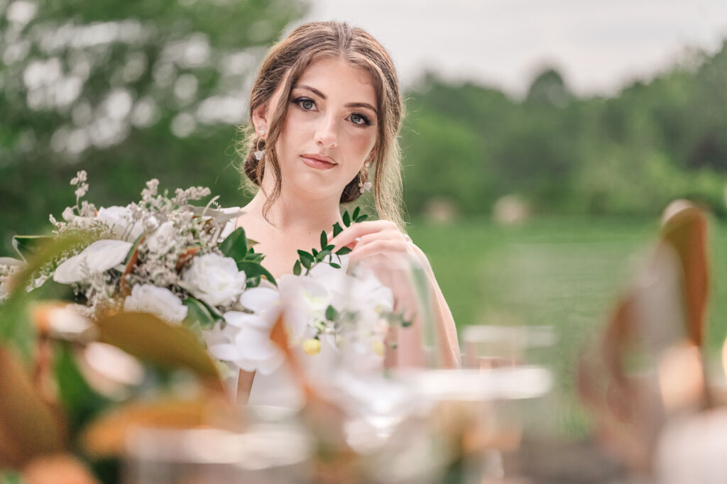 A playful brunette bride enjoying her summer outdoor bridal portrait session at Firefly Haven by JoLynn Photography