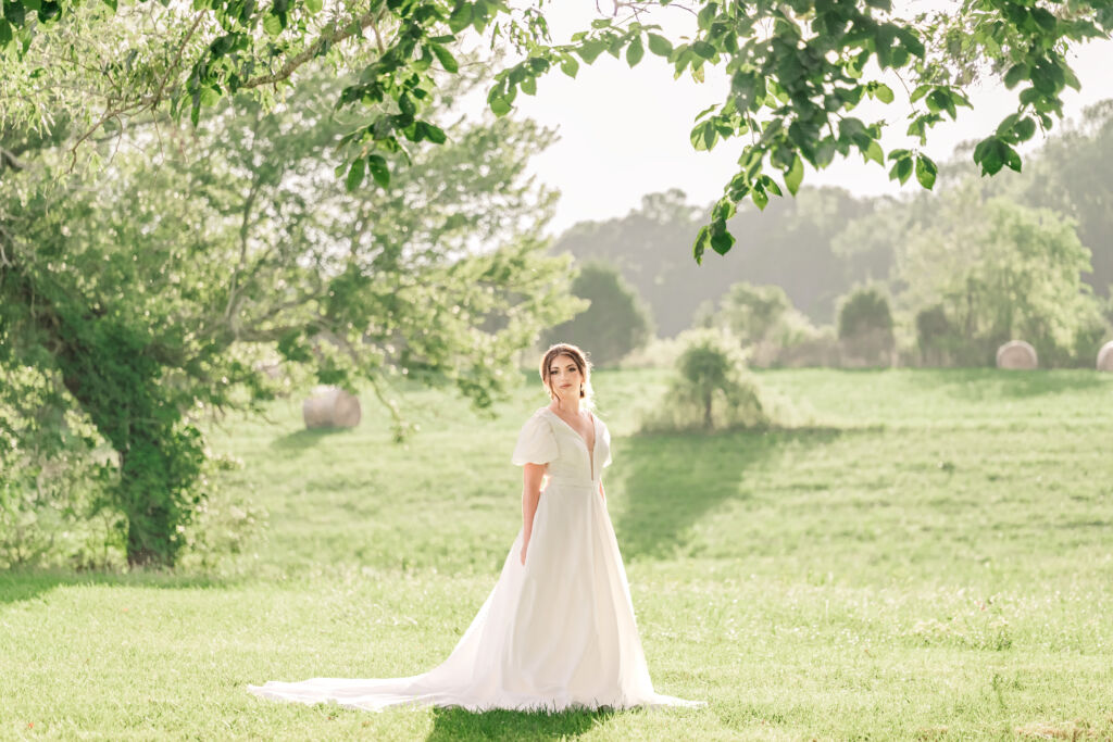 A playful brunette bride enjoying her summer outdoor bridal portrait session at Firefly Haven by JoLynn Photography