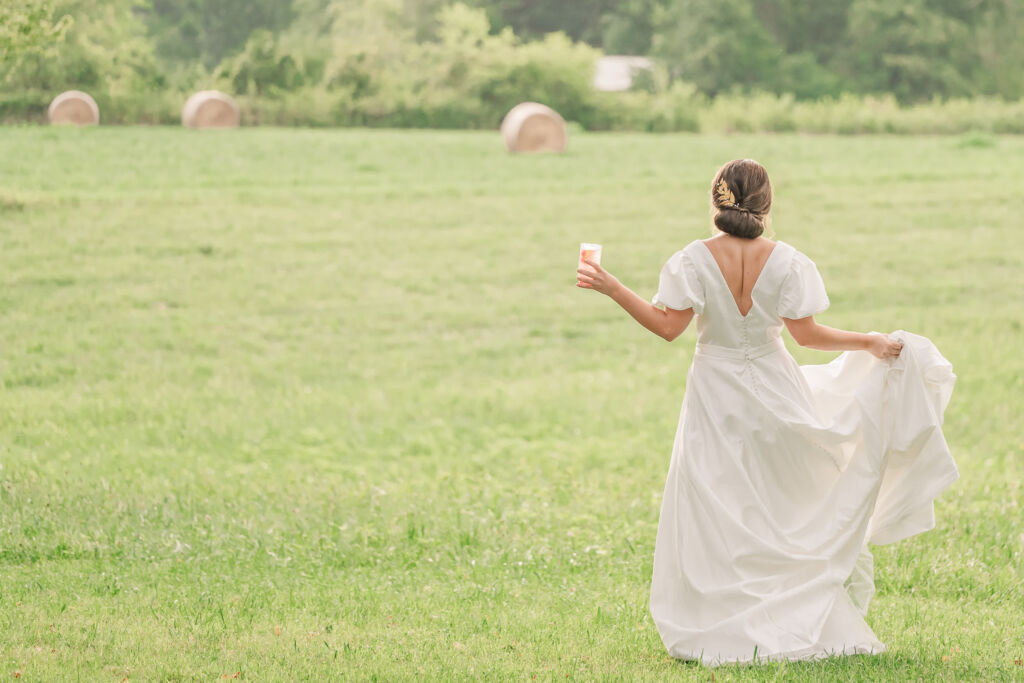 A playful brunette bride enjoying her summer outdoor bridal portrait session at Firefly Haven by JoLynn Photography