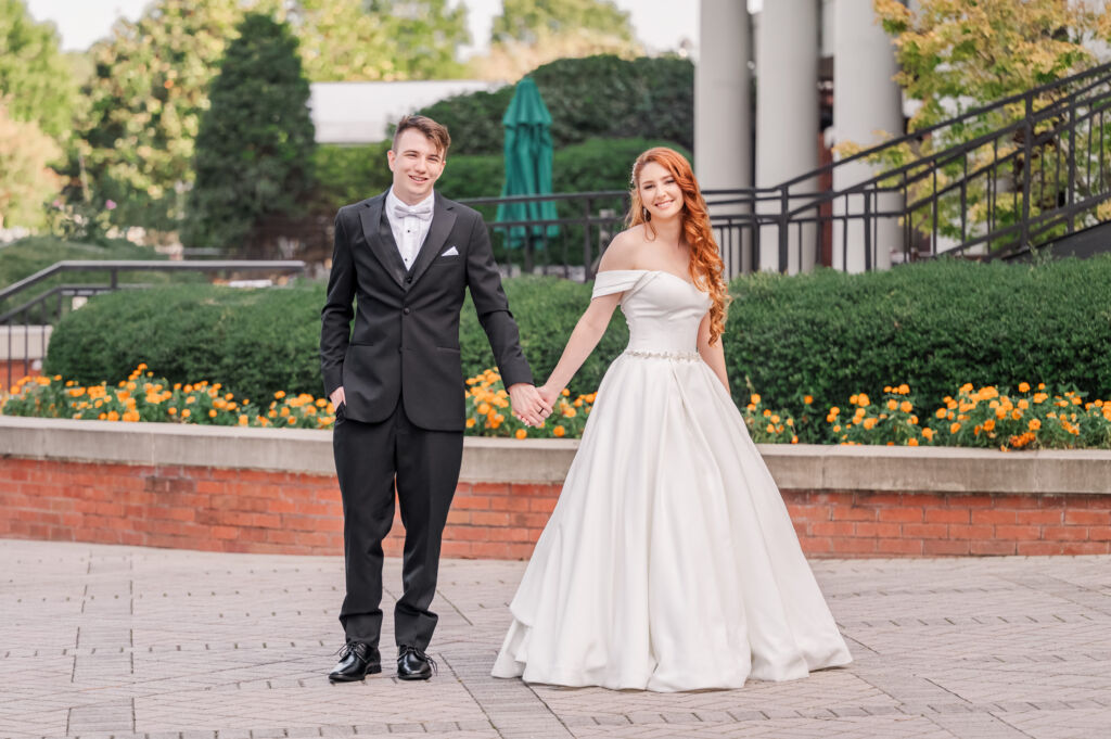 A loving couple holding hands at sunset after saying I do at their Prestonwood country club wedding by JoLynn Photography