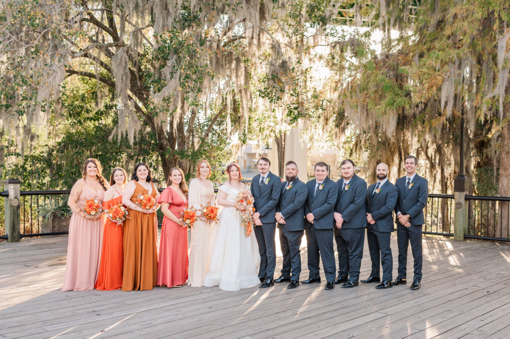 A wedding party on the riverwalk near the Peanut Warehouse at sunset during their fall wedding by JoLynn Photography