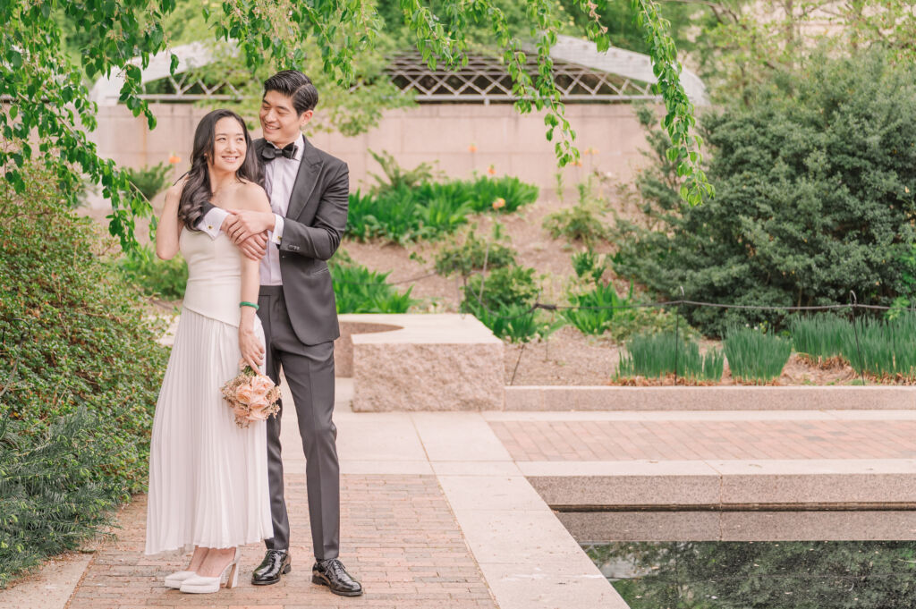 A loving happy Asian couple celebrating their spring engagement next to iconic DC monuments by Washington DC wedding photographer, JoLynn Photography