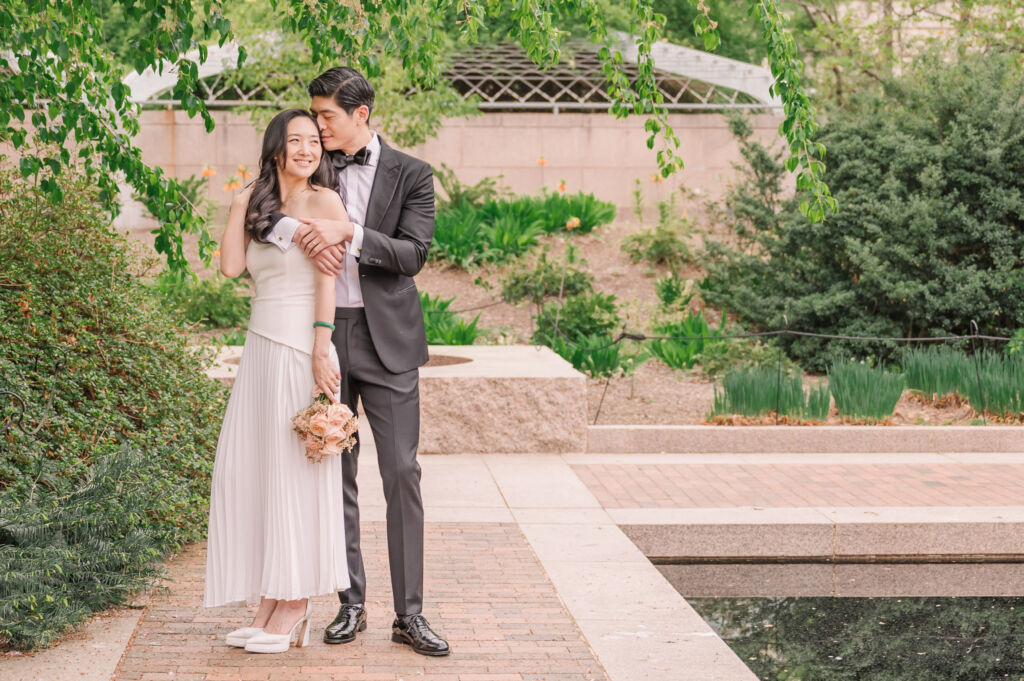 A loving happy Asian couple celebrating their spring engagement next to iconic DC monuments by Washington DC wedding photographer, JoLynn Photography
