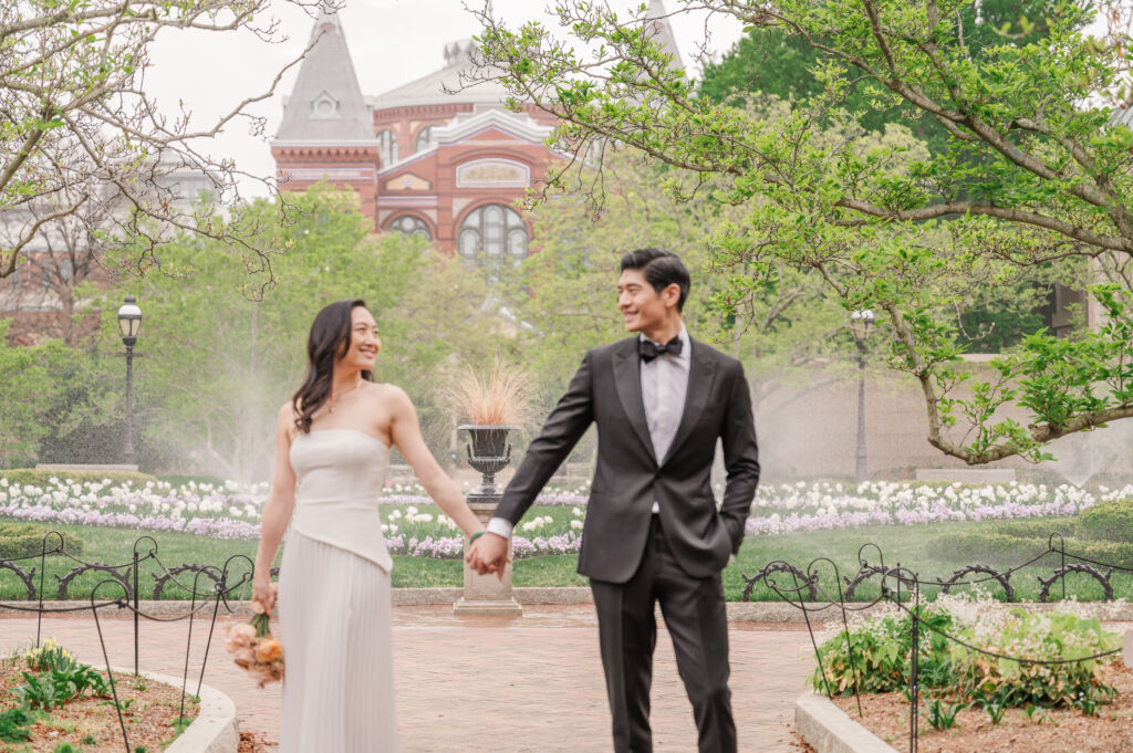 A loving happy Asian couple celebrating their spring engagement next to iconic DC monuments by Washington DC wedding photographer, JoLynn Photography