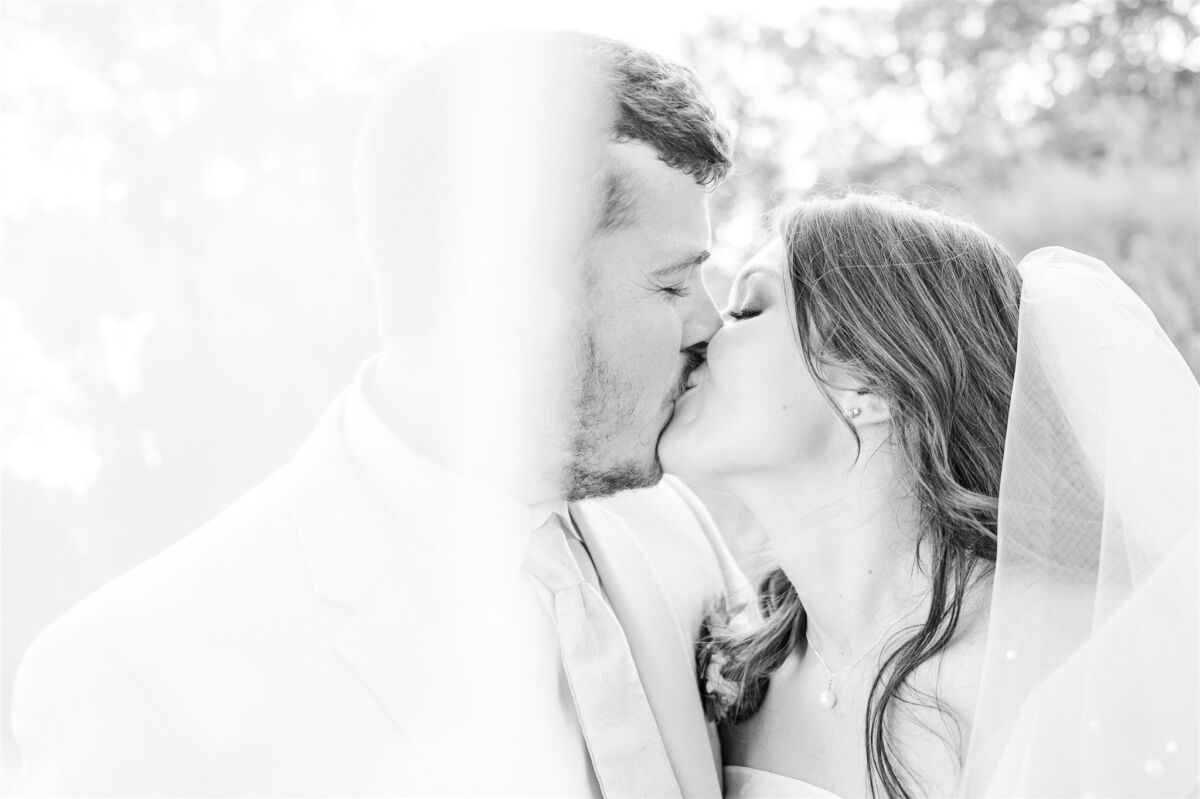 Newlyweds kiss while hiding behind the veil at one of the North Carolina beach wedding venues