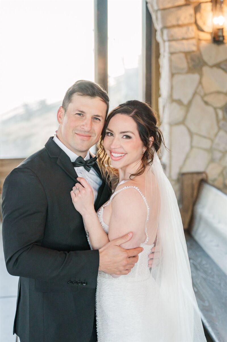 Newlyweds snuggle in a stone chapel in a black tuxedo at one of the North Carolina mountain wedding venues