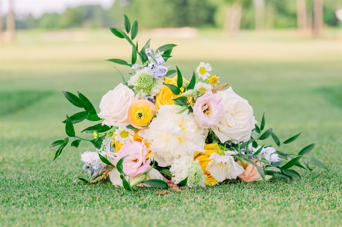 Details of a colorful bouquet laying in the grass at a golf course