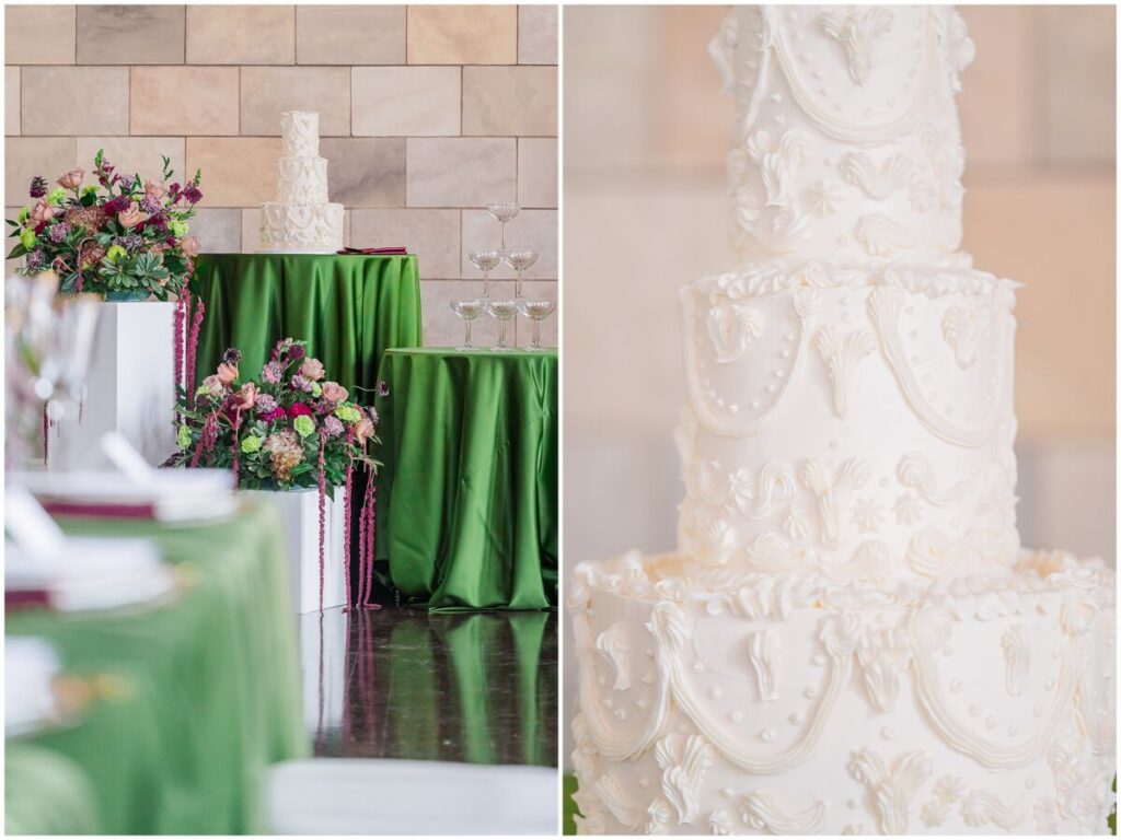 A stunning white three tiered cake surrounded by green and red wedding reception details at Dover Hall Estate