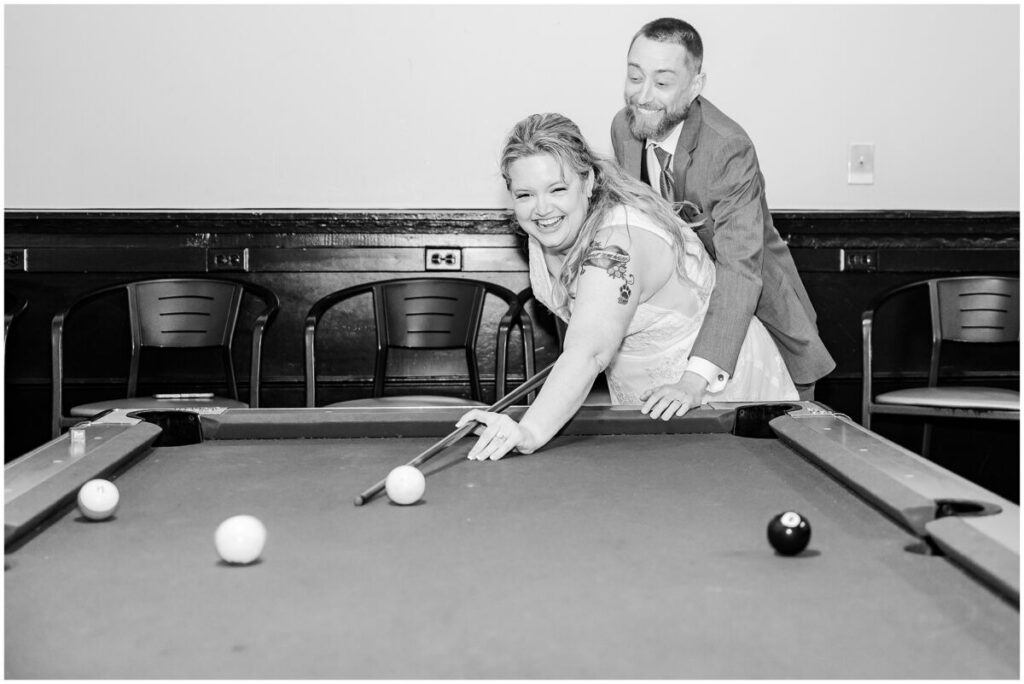 A happy couple playing pool at their wedding