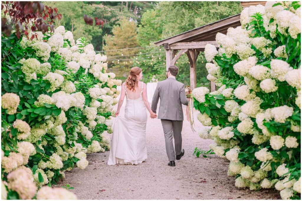 A happy couple walking to their wedding reception after an amazing wedding at Big Spring Farm