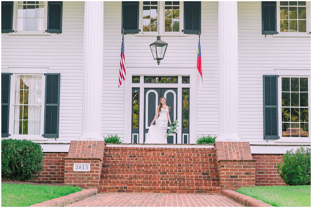 A happy bride on the front porch of Rose Hill Estate during the summer time