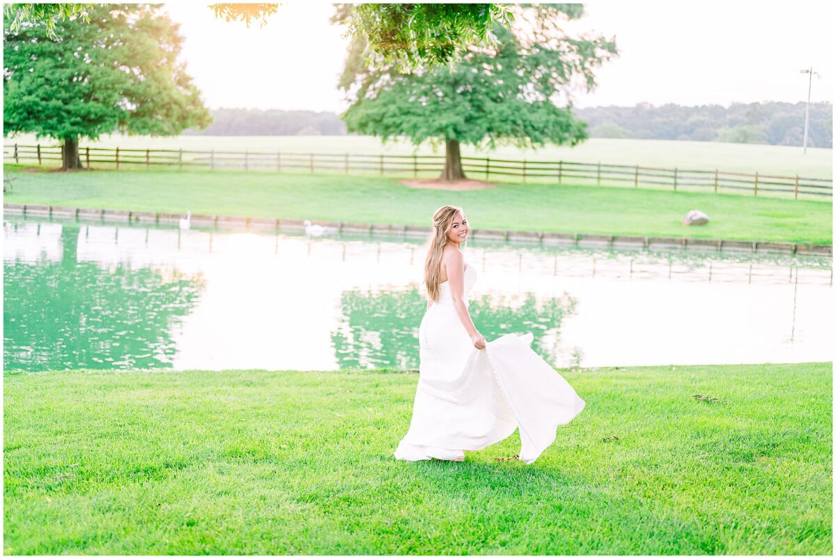 A fun blonde bride being carefree during her Rose Hill Estate bridal portrait session at sunset by JoLynn Photography overlooking the water